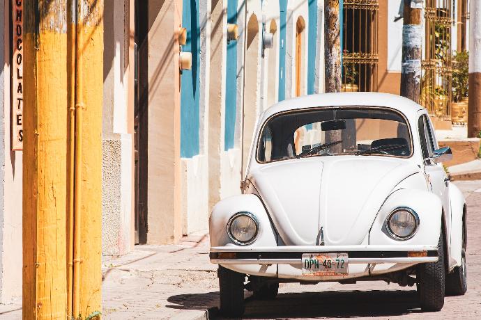 white volkswagen beetle parked beside building during daytime